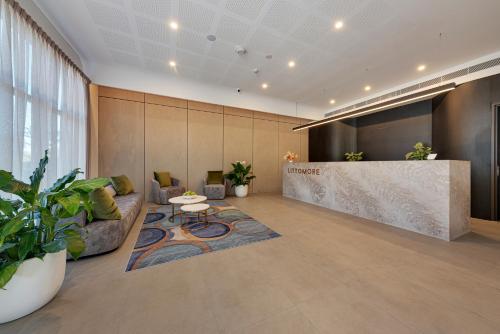 an office lobby with a counter and a table at Littomore Suites Kingswood in Penrith