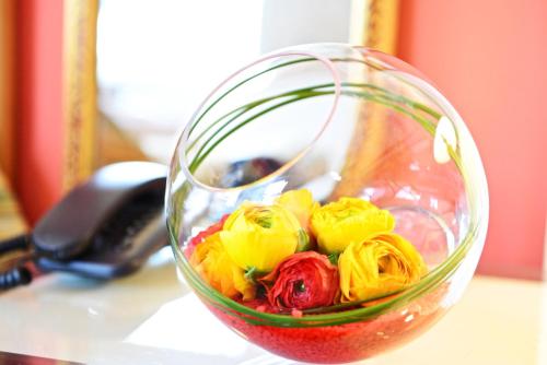 a glass vase filled with colorful flowers on a table at Villa Le Logge in Ventimiglia