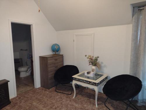 una stanza con due sedie nere e un tavolo con un vaso di Quiet upstairs studio close to town 420 friendly a Trinidad