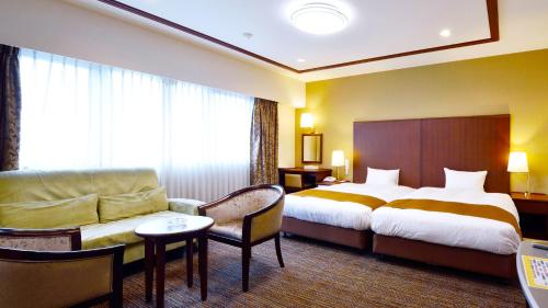 a hotel room with a bed and a couch at Hotel GRANDSPA AVENUE in Asakura