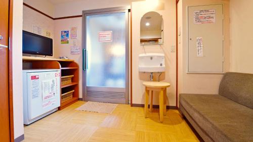 a small room with a sink and a couch at Hotel GRANDSPA AVENUE in Asakura
