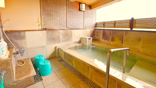 a bathroom with a hot tub and a sink at Hotel GRANDSPA AVENUE in Asakura