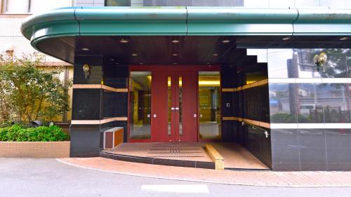 a building with a red door in front of it at Hotel GRANDSPA AVENUE in Asakura