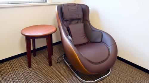 a chair and a stool in a room at Hotel GRANDSPA AVENUE in Asakura