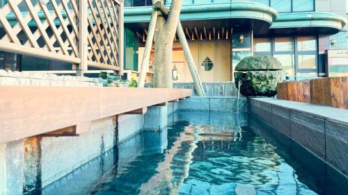 a pool of water in front of a building at Hotel GRANDSPA AVENUE in Asakura