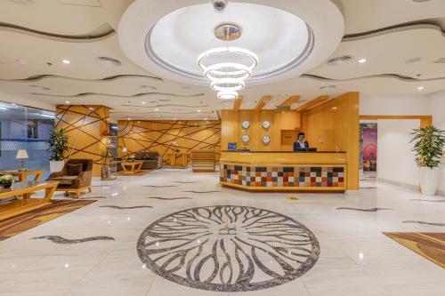 a lobby with a reception desk and a large ceiling at Roda Amwaj Suites Jumeirah Beach Residence in Dubai