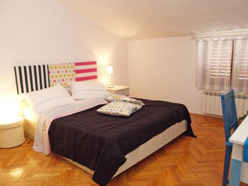 a bedroom with a large bed with a black blanket at Family Friendly Apartments in Pula