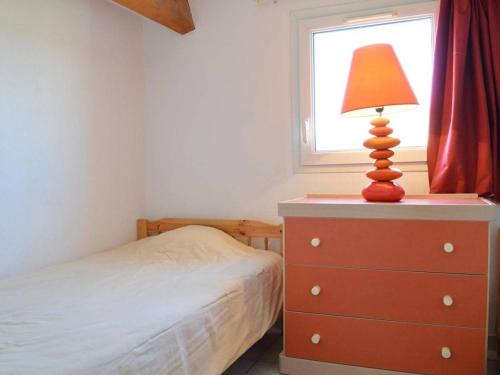 une chambre avec un lit et une lampe sur une commode dans l'établissement Villa Familiale 8 Pers. à 600m de la Plage avec Piscine et Terrasse Ensoleillée à Cap d'Agde - FR-1-249-103, au Cap d'Agde