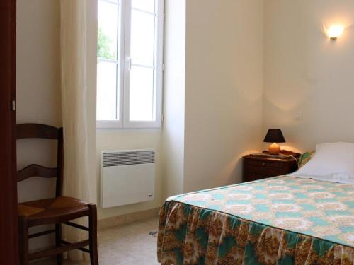 1 dormitorio con cama, ventana y silla en Maison La Brée-les-Bains, 3 pièces, 4 personnes - FR-1-246A-74, en La Brée-les-Bains