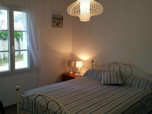 une chambre avec un lit, une fenêtre et un lustre dans l'établissement Maison contemporaine 3 chambres à 400m de la plage avec WiFi – Saint-Georges-d'Oléron - FR-1-246A-24, à Chaucre