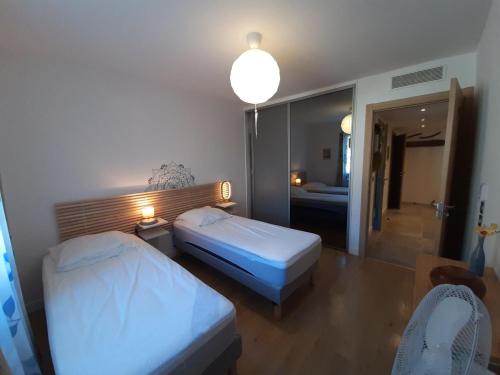 Habitación de hotel con 2 camas y espejo en Appartement Soorts-Hossegor, 2 pièces, 4 personnes - FR-1-239-583, en Soorts-Hossegor