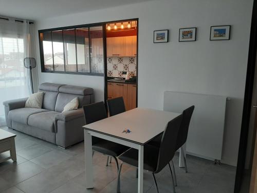 un salon avec une table, des chaises et un canapé dans l'établissement Appartement T3 rénové à 10 min du centre-ville avec balcon, garage et WIFI à Saint-Jean-de-Luz - FR-1-239-584, à Saint-Jean-de-Luz