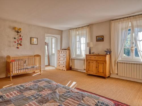 ein Schlafzimmer mit einem Kinderbett, einer Kommode und Fenstern in der Unterkunft Maison Saint-Rémy-de-Provence, 8 pièces, 12 personnes - FR-1-599-4 in Saint-Rémy-de-Provence