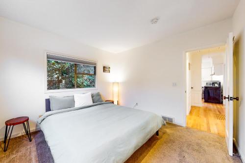 a white bedroom with a large bed and a window at Woodlawn Escape in Seattle
