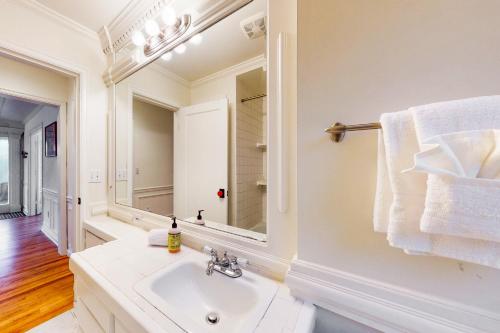 a white bathroom with a sink and a mirror at Woodlawn Escape in Seattle