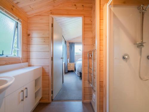 La salle de bains privative est pourvue d'un lavabo et d'une douche. dans l'établissement Ocean Beach Beauty - Tairua Holiday Home, à Tairua