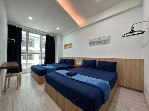 a bedroom with two beds with blue sheets and a window at SA Sutera Avenue Homestay Opposite Imago KK in Kota Kinabalu
