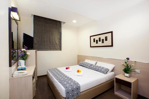 una camera d'albergo con letto e TV di Hotel 81 Fuji a Singapore