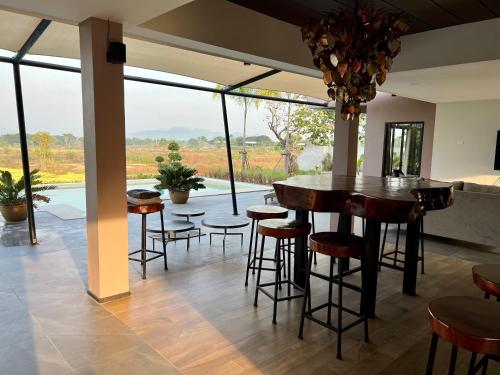 a room with a bar with stools and a view at I love phants Lodge in Ban Huai Thawai