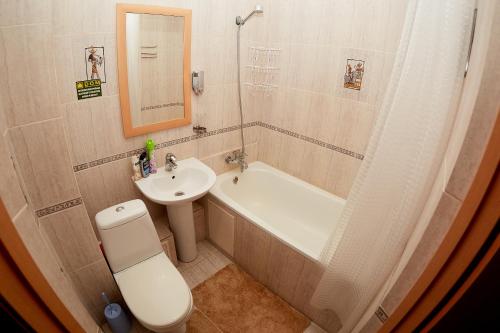 uma casa de banho com um lavatório, um WC e uma banheira em Сидней em Petropavl