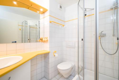 a bathroom with a toilet and a sink and a shower at null Haus Frisia, Whg 407 in Sankt Peter-Ording