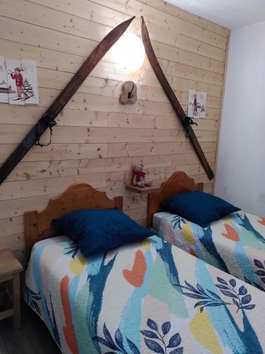 - une chambre avec 2 lits dans un mur en bois dans l'établissement Appartement 2 Chbres Calme Vue vallée 500m des pistes, au Corbier