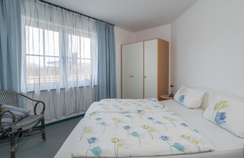 ein Schlafzimmer mit einem Bett, einem Stuhl und einem Fenster in der Unterkunft null Haus Frisia, Whg 404 in Sankt Peter-Ording