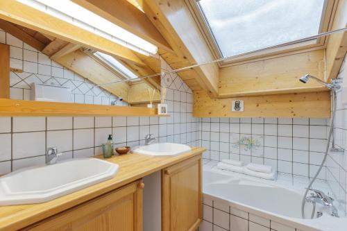 ein Badezimmer mit zwei Waschbecken, einer Badewanne und einem Fenster in der Unterkunft Village des Oursons C - Happy Rentals in Chamonix-Mont-Blanc