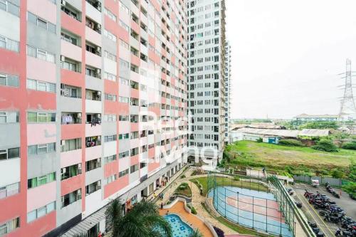 een uitzicht op een hoog gebouw met een zwembad in het midden bij RedLiving Apartemen Sentra Timur Residence - Myroom id Tower Green in Jakarta