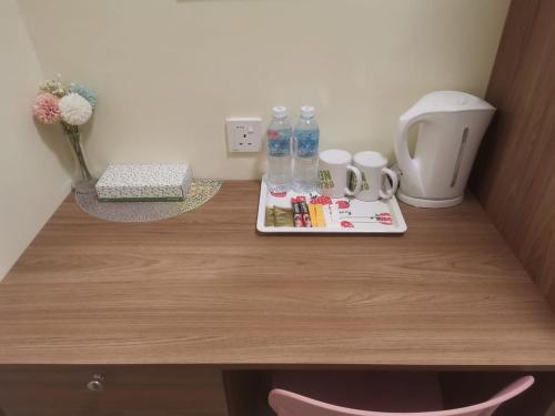 a wooden desk with a tray of items on it at SCC Hotel Chinatown in Kuala Lumpur