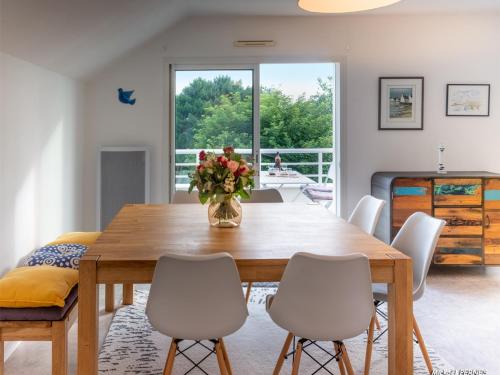 une salle à manger avec une table et des chaises en bois dans l'établissement Larmor-Plage : Appartement T3 avec Terrasse et Garage - FR-1-349-155, à Larmor-Plage