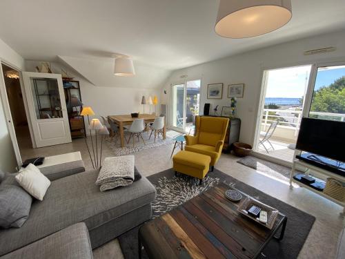 un salon avec un canapé, une télévision et une table dans l'établissement Larmor-Plage : Appartement T3 avec Terrasse et Garage - FR-1-349-155, à Larmor-Plage