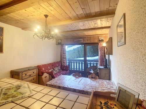 un salon avec un canapé et une table dans l'établissement Studio cosy avec cabine, pied des pistes à Combloux, balcon, casier à skis, équipements modernes - FR-1-560-56, à Combloux