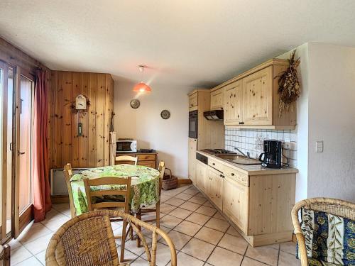 une cuisine avec une table et des chaises dans une pièce dans l'établissement Charmant 2 pièces cabine avec jardin, près de Combloux - FR-1-560-33, à Combloux