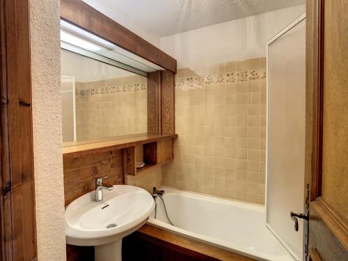 une salle de bain avec un lavabo et une baignoire dans l'établissement Studio Cabine avec Jardin Privatif près du Téléski du Bouchet - Combloux - FR-1-560-40, à Combloux
