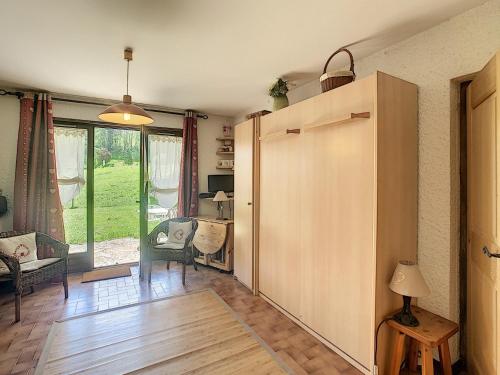 - un salon avec une grande porte coulissante, une table et des chaises dans l'établissement Studio de 25m² au pied des pistes avec kitchenette, terrasse et casier à skis - FR-1-560-57, à Combloux
