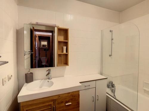 ein weißes Bad mit einem Waschbecken und einer Dusche in der Unterkunft Studio Combloux, 1 pièce, 2 personnes - FR-1-560-54 in Combloux