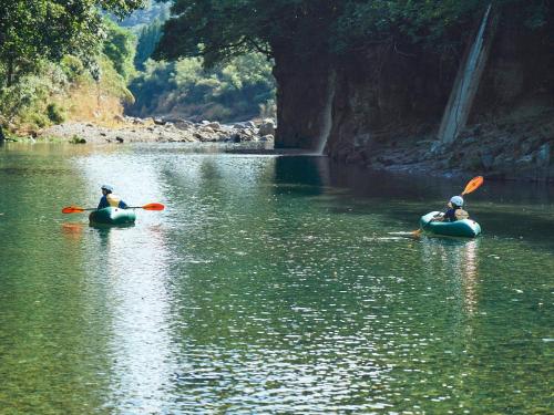 two people are in kayaks on a river at Lodge Kiyokawa in Bungoono