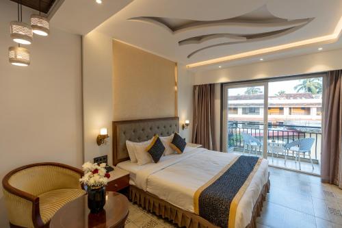 a hotel room with a bed and a balcony at Alvorada Resort-3 Star Resort In Baga in Arpora