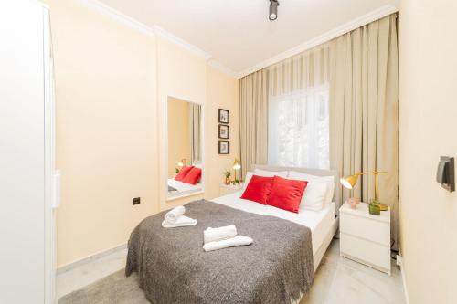 a bedroom with a large bed with red pillows at Modern Flat with Shared Pool and Balcony in Alanya in Avsallar