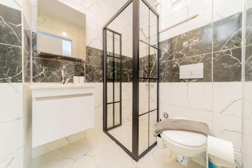 a bathroom with a toilet and a mirror at Modern Flat with Shared Pool and Balcony in Alanya in Avsallar