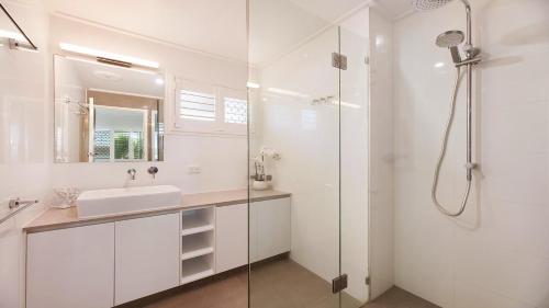 a white bathroom with a sink and a shower at 20 Mackay St Dicky Beach QLD in Caloundra