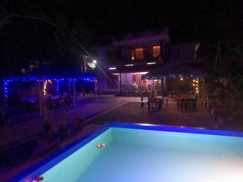 an empty swimming pool at night with a table at Casa Eva Luna Ayuryoga Retreat in Varkala