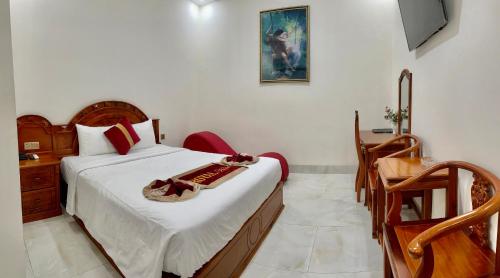 een slaapkamer met een bed, een tafel en een bureau bij Royal Hotel 2 in Bạc Liêu