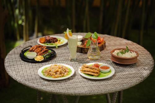 a table with plates of food on top at Raindrops Resorts Wayanad in Sultan Bathery