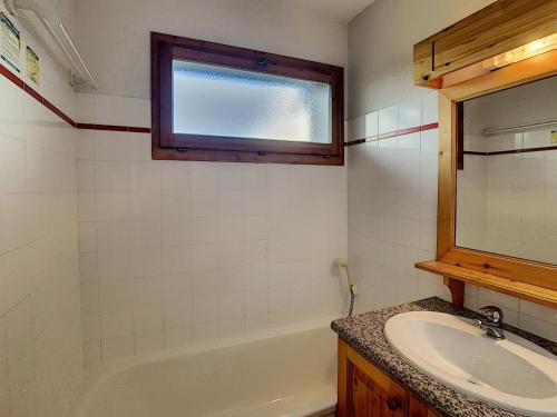 La salle de bains est pourvue d'un lavabo, d'une baignoire et d'une fenêtre. dans l'établissement Appartement cosy 2 pièces à 2 pas des remontées mécaniques de Combloux - FR-1-560-20, à Combloux