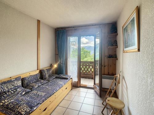 een slaapkamer met een bed en uitzicht op een balkon bij Appartement Combloux, 3 pièces, 6 personnes - FR-1-560-5 in Combloux