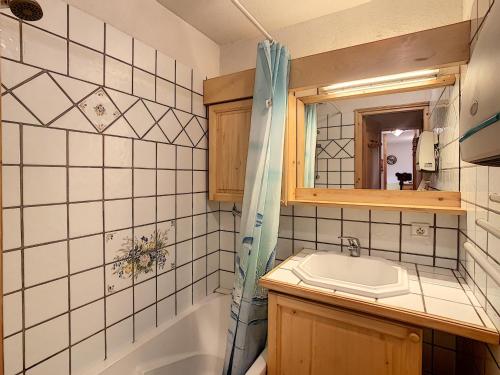 een badkamer met een wastafel, een bad en een spiegel bij Appartement Combloux, 3 pièces, 6 personnes - FR-1-560-5 in Combloux