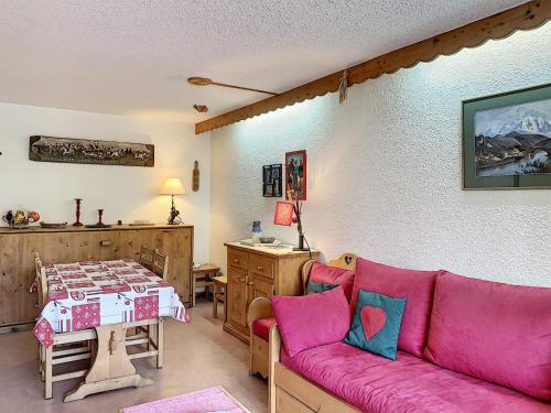 un salon avec un canapé rose et une table dans l'établissement Charmant 2 pièces au centre de Combloux avec balcon, parking et proche ski bus - FR-1-560-2, à Combloux
