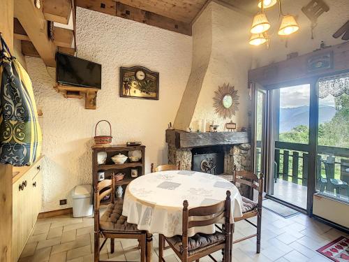 une salle à manger avec une table et une cheminée dans l'établissement Duplex 35m² à 2 pas du centre de Combloux, 4 couchages, balcon, proche pistes - FR-1-560-19, à Combloux